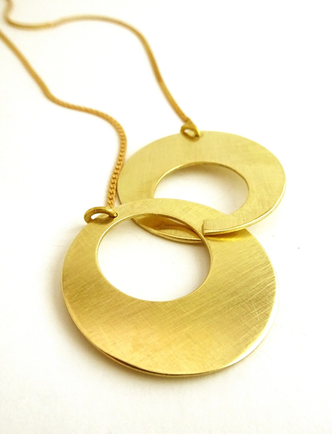 Collier Duo Cercles grand modèle en laiton doré – deux anneaux entrelacés, bijou artisanal Maison Niléa.