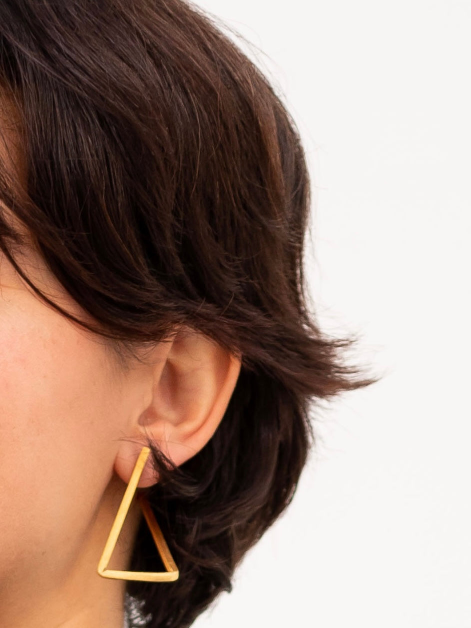 Boucles d’oreilles Les Hoops en laiton doré portée.