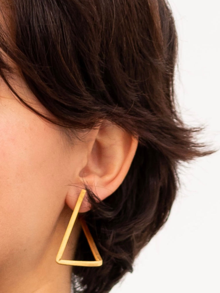 Boucles d’oreilles Les Hoops en laiton doré portée.