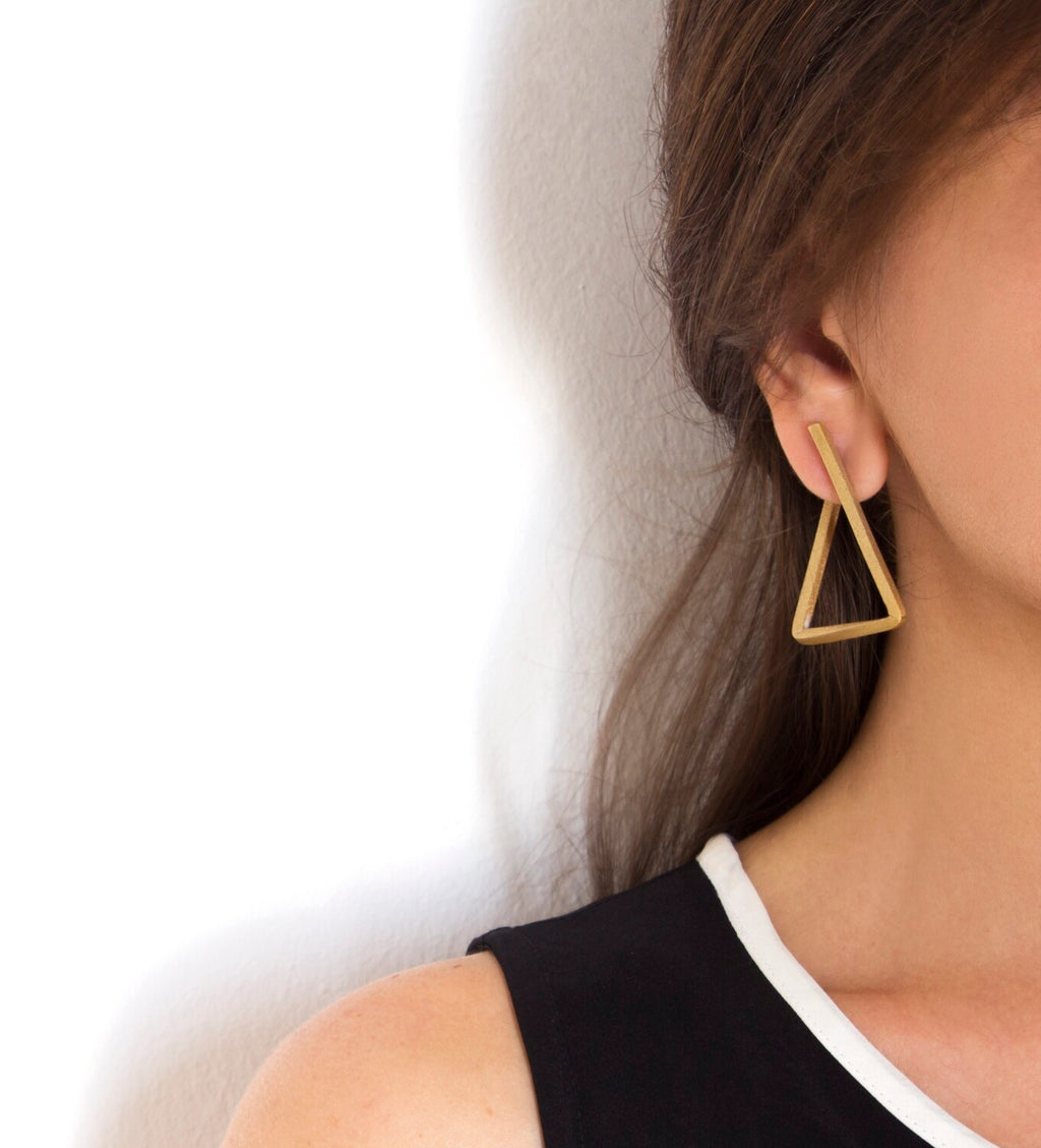 Boucles d’oreilles Les Hoops triangle portées à l’oreille, design épuré en laiton doré à l'or fin – Niléa.