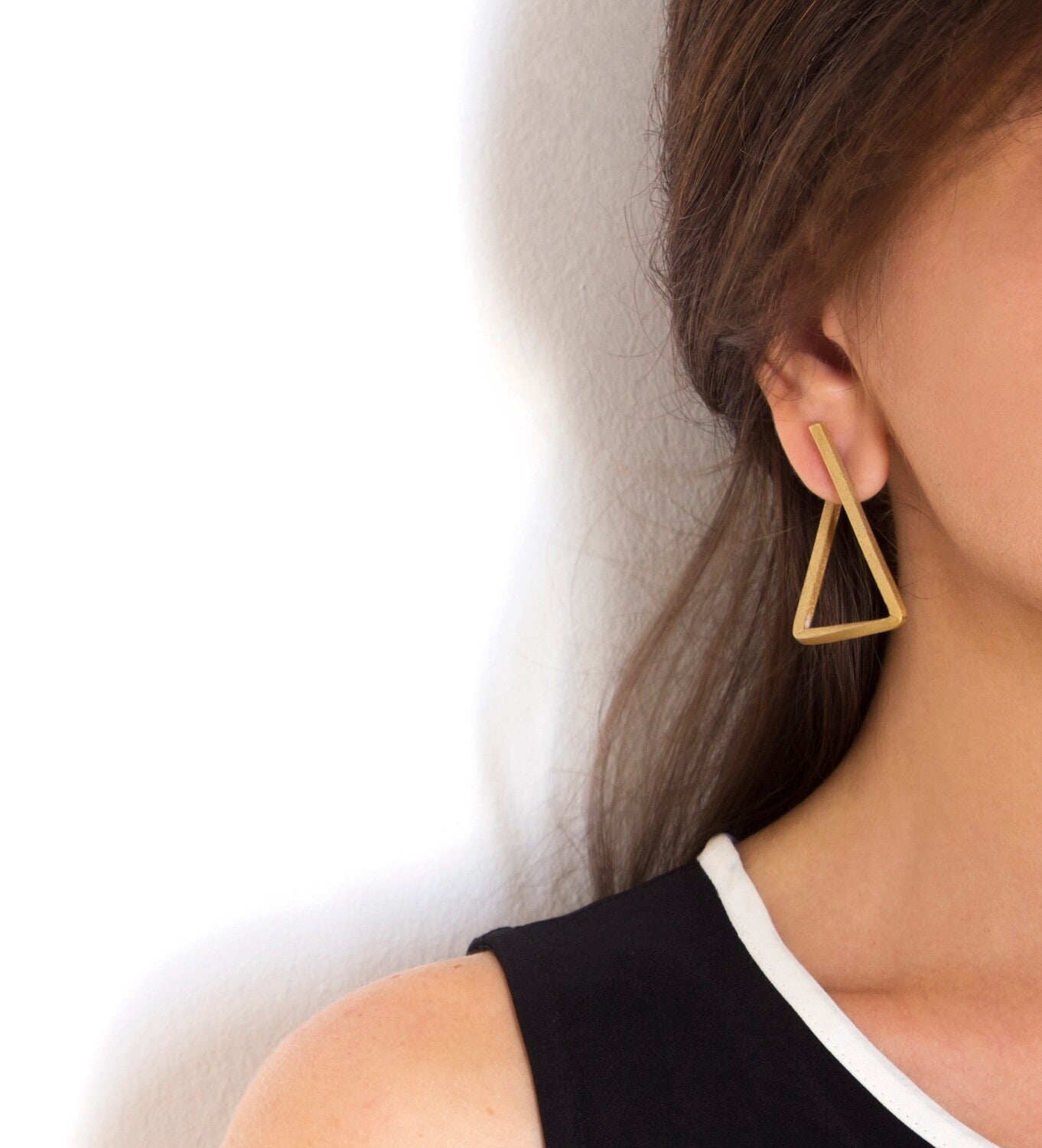 Boucles d’oreilles Les Hoops triangle portées à l’oreille, design épuré en laiton doré à l'or fin – Niléa.