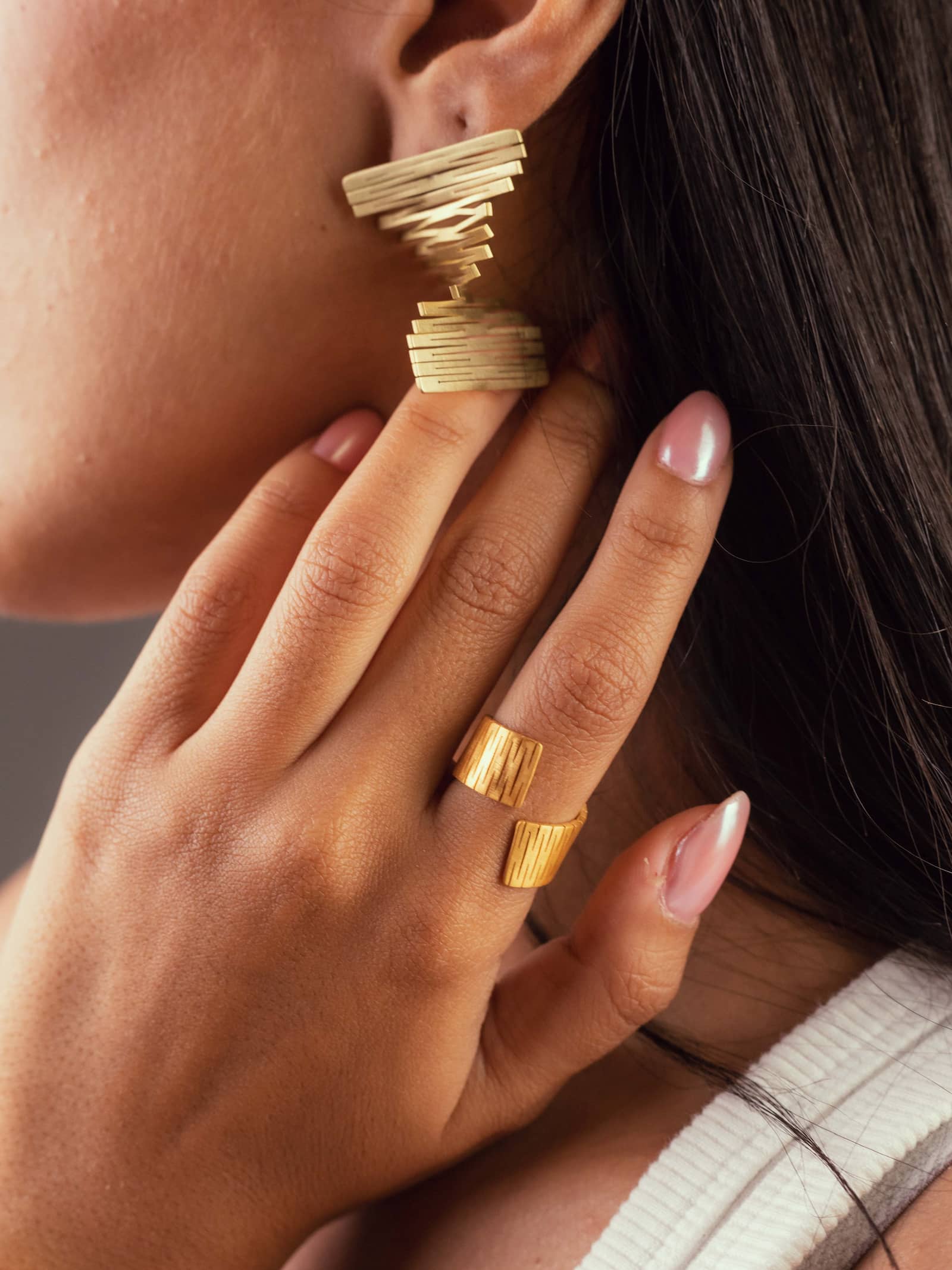 Une fille qui porte les Boucles d'oreilles Liquify carré modulables en forme éventail en la bague Liquify