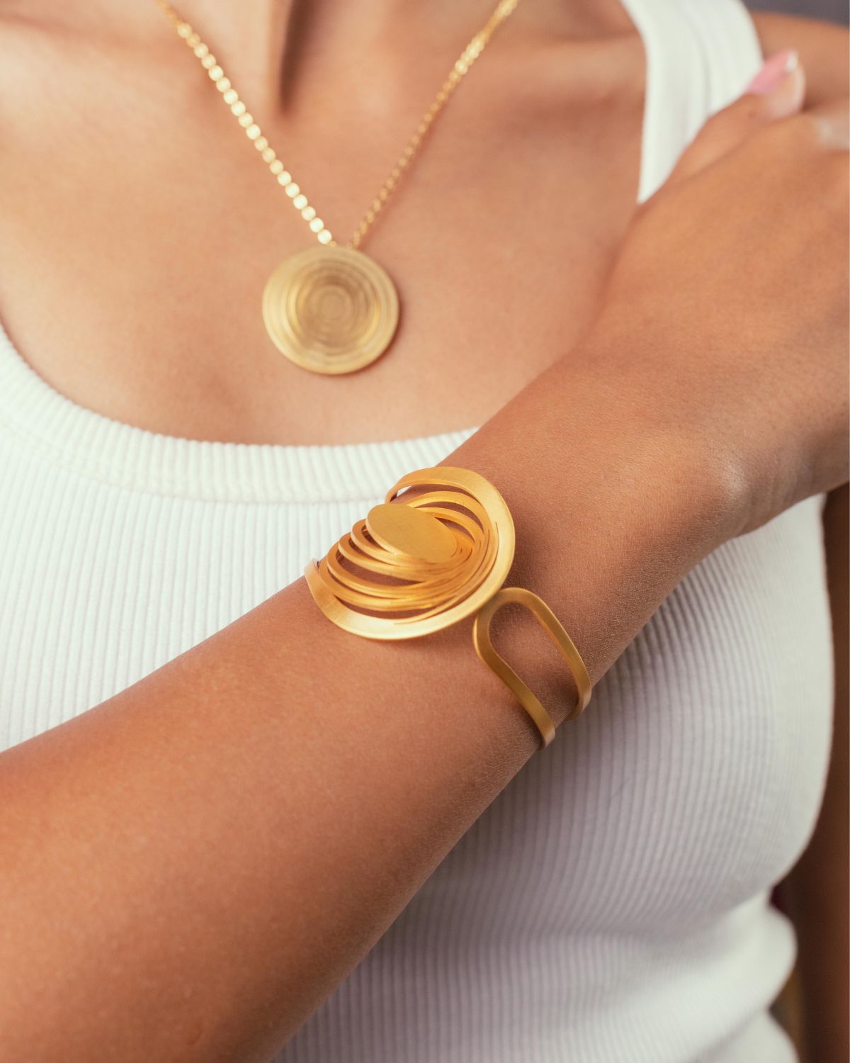 Une fille qui porte l'ensemble de bracelet et collier Liquify Orbits. bijoux modulables en laiton Niléa