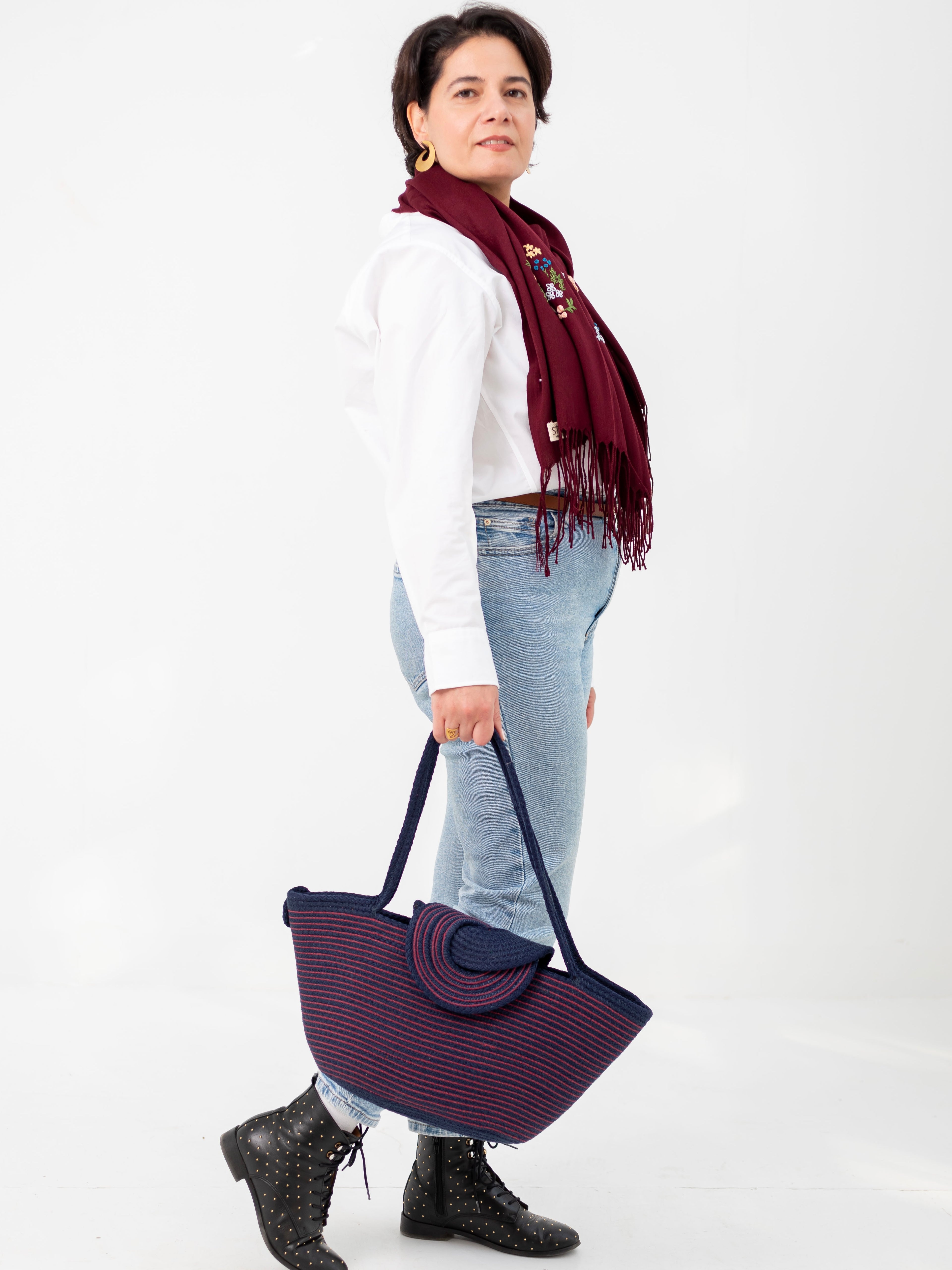 Cabas Marsa bleu marine et rouge porté à la main par la fondatrice de la marque Niléa.