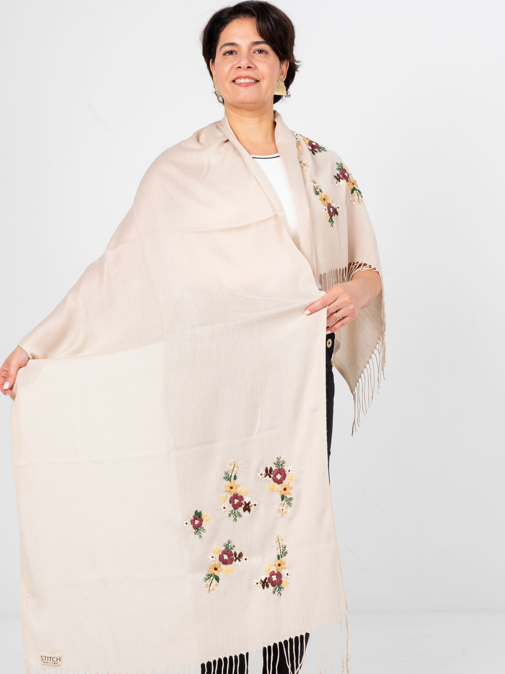 Écharpe Lana beige portée en longueur pour montrer le détails de la broderie sur 2 côtés.