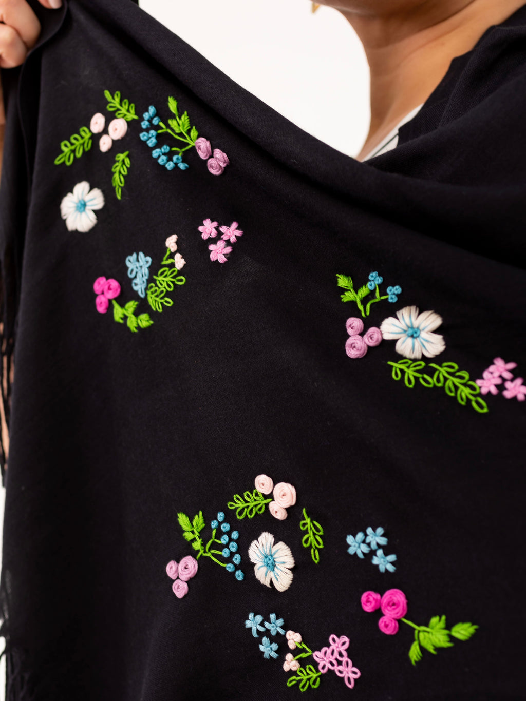 Détail de broderies florales faites main sur l’écharpe Leila noire