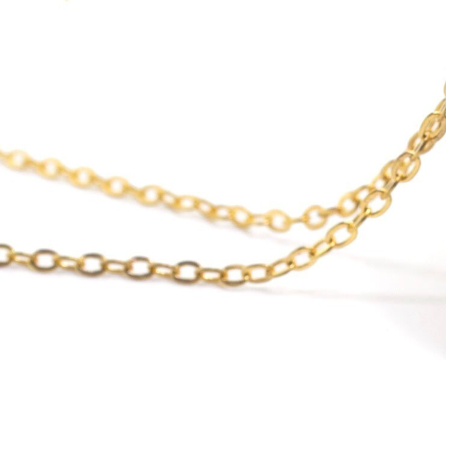 Détail de la chaîne du collier, bijou en laiton avec finition artisanale.