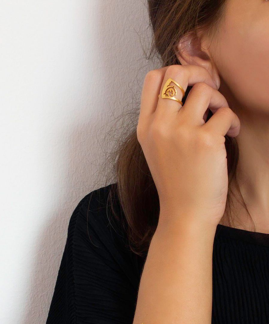 Bague Fleur Niléa portée à la main, bijou en laiton doré à l'or fin et sans nickel au motif floral.