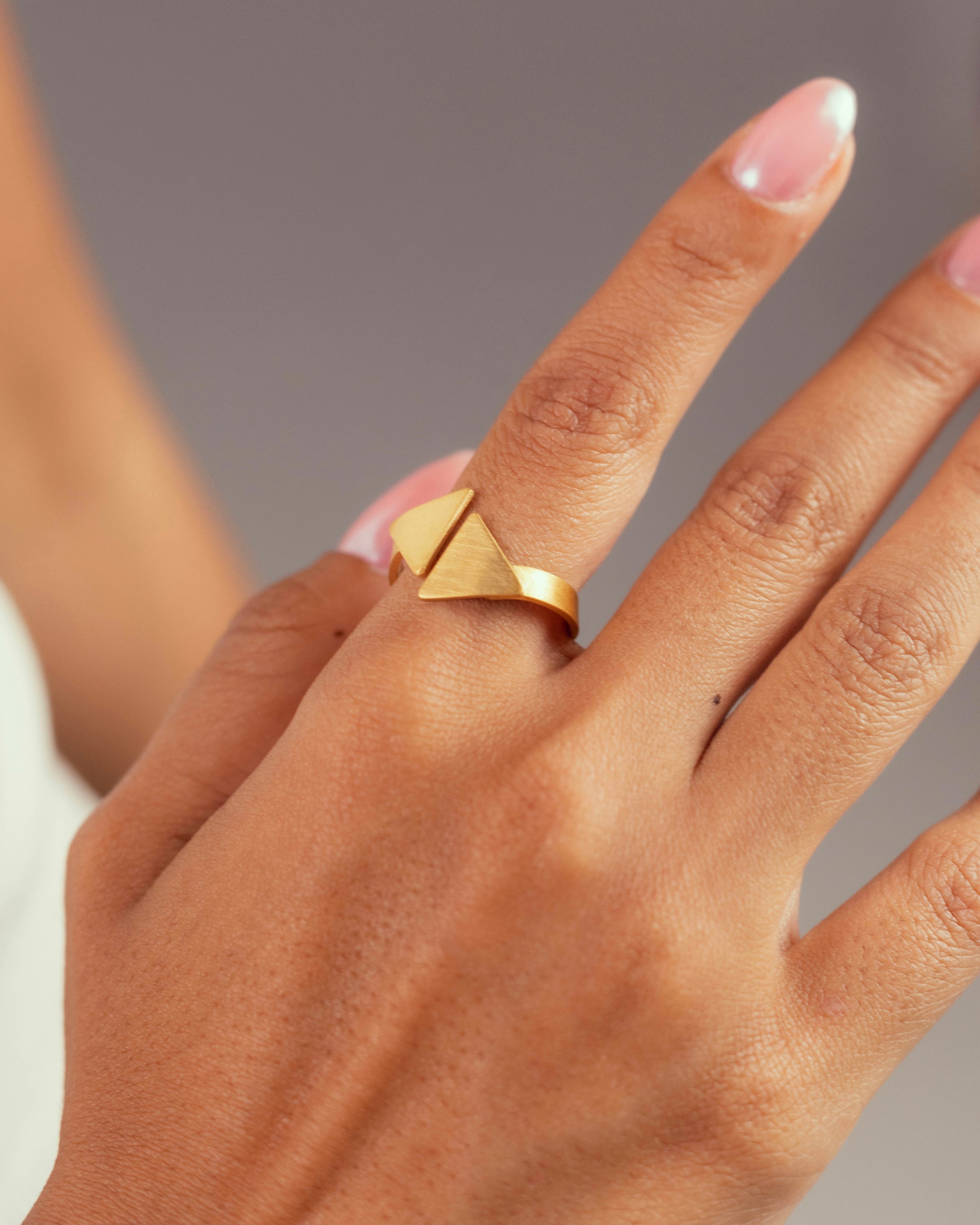 Bague pyramide Niléa portée, deux triangles en laiton doré à l'or fin modulable.
