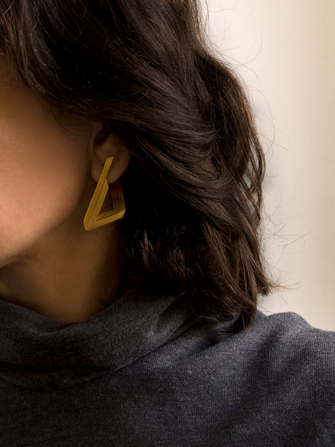 Boucles d’oreilles géométriques en laiton à l'or fin portées, création artisanale Niléa.