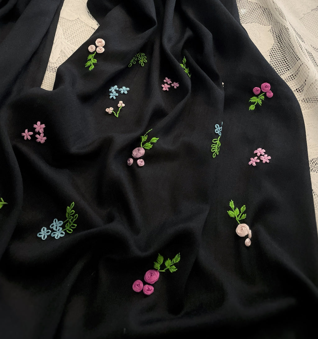 Détails broderie petites fleurs sur un coté de l'écharpe Leila sur fond blanc