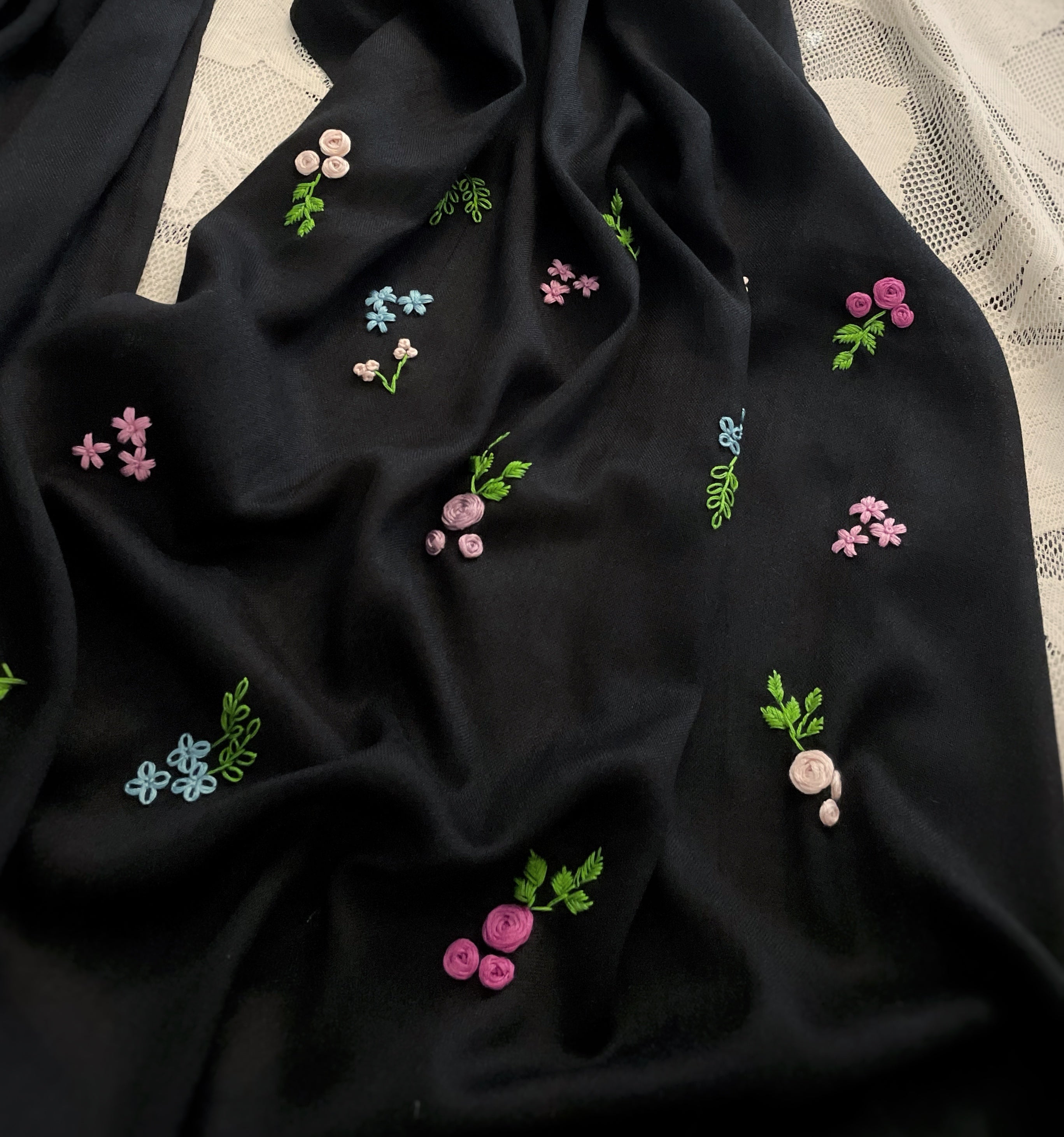 Détails broderie petites fleurs sur un coté de l'écharpe Leila sur fond blanc