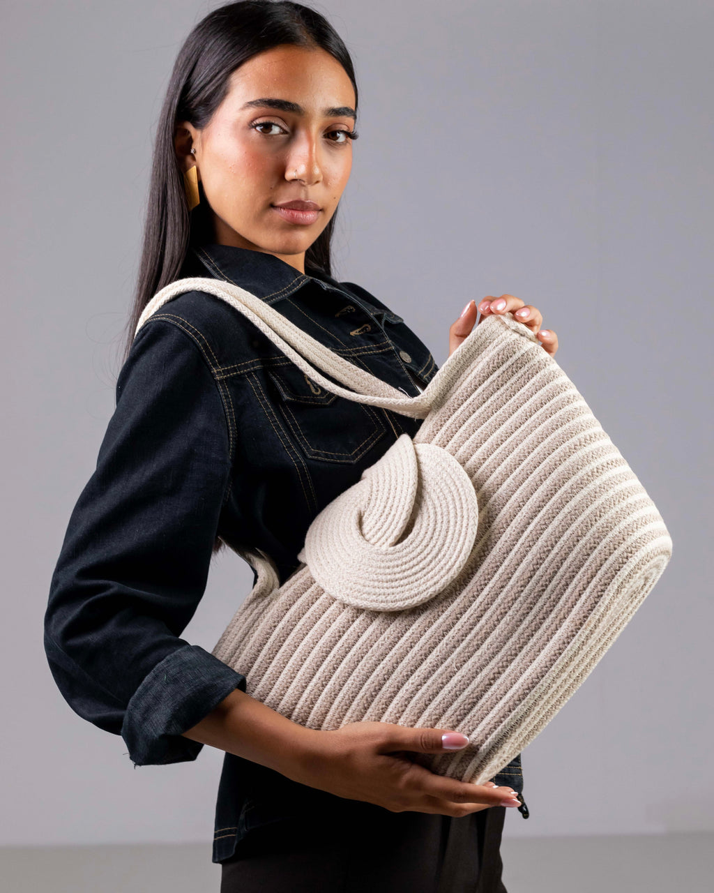 Sac à main Dahab aux rayures balnc et beige porté par un mannequin