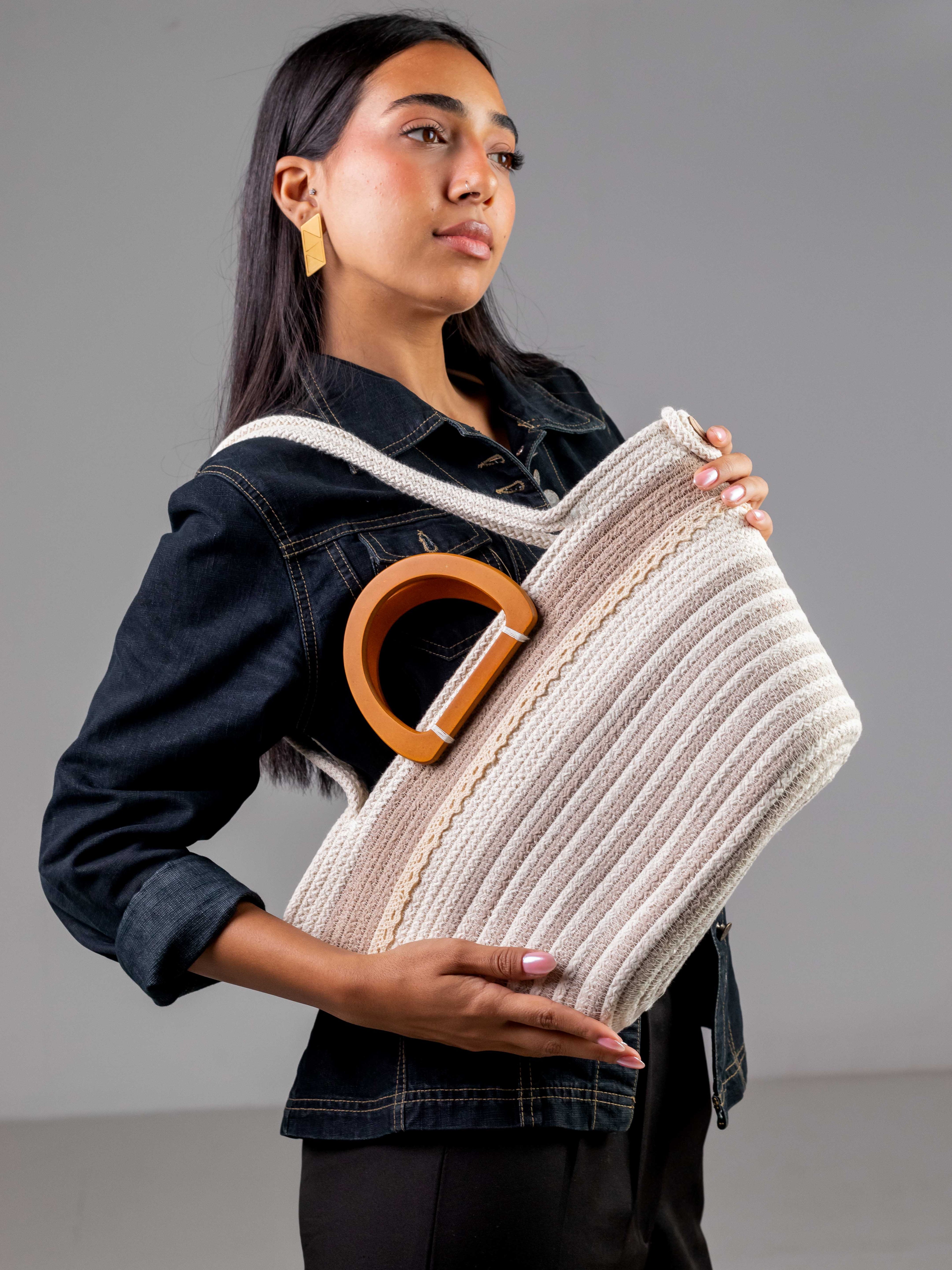 Mannequin portant à l'épaule le sac cabas Farafra bicolore blanc et beige, associant des anses en bois et une tenue en jean moderne.