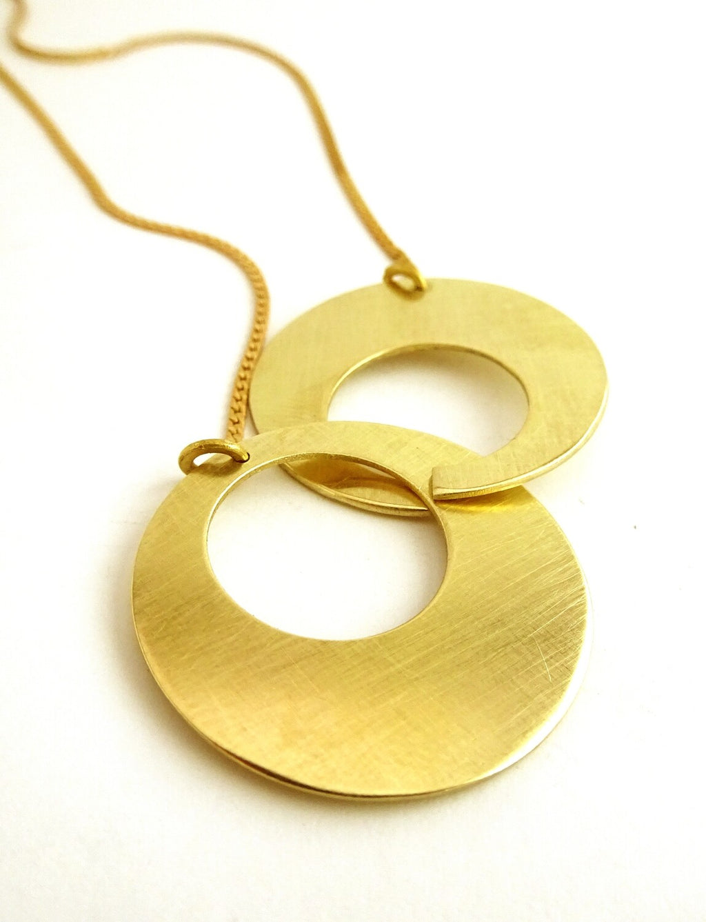Collier Duo Cercles grand modèle en laiton doré – deux anneaux entrelacés, bijou artisanal Maison Niléa.