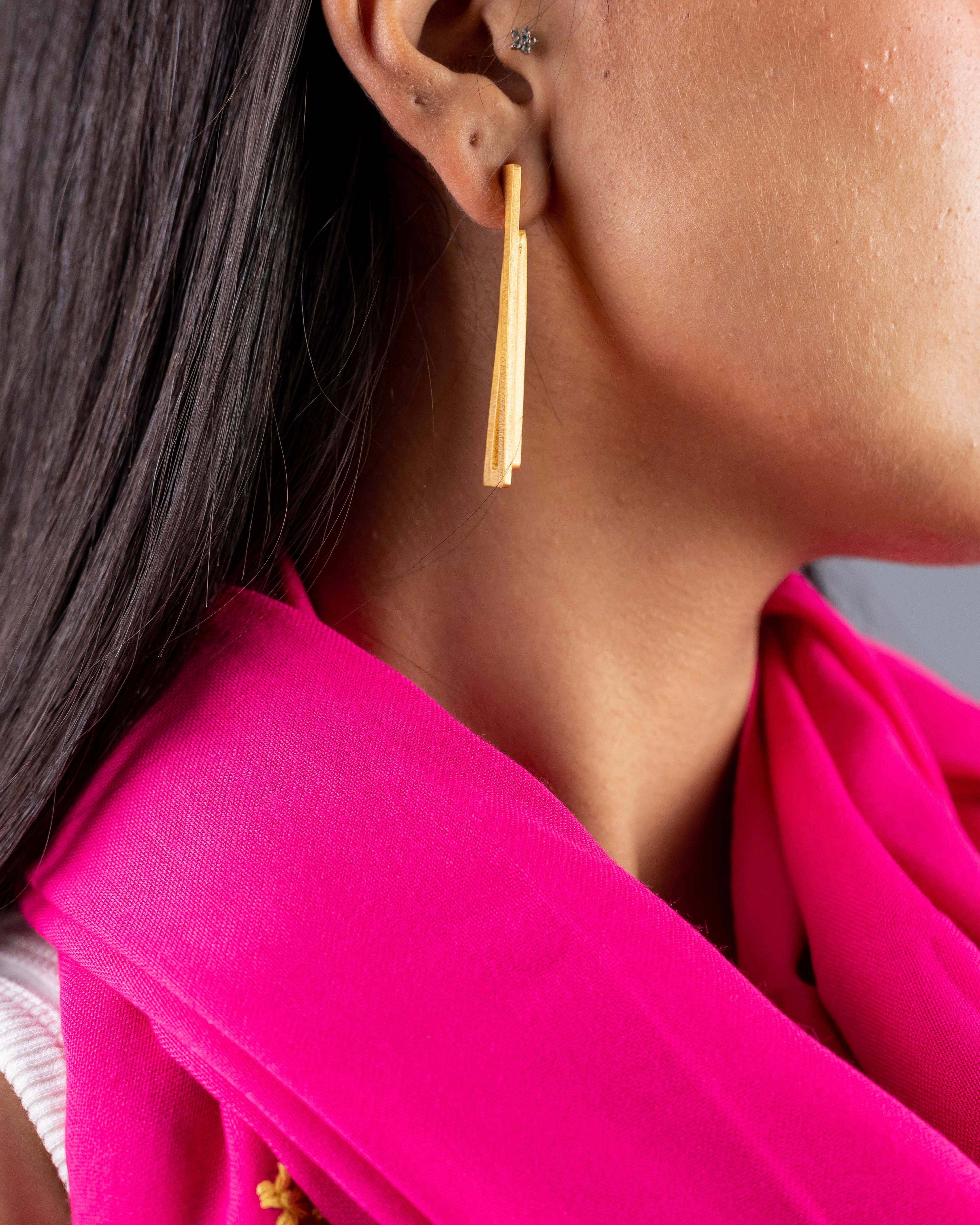 Gros plan sur boucles d'oreilles double ligne Niléa portées
