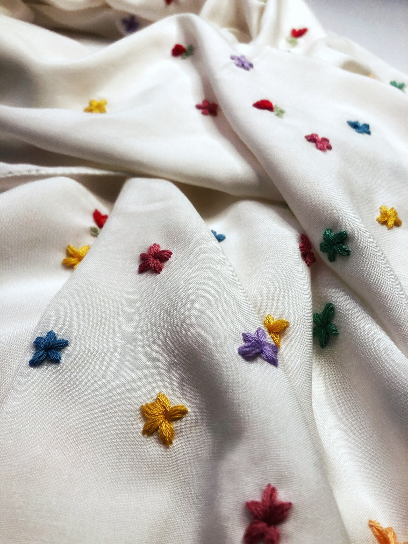 Détail de broderies florales faites main sur le foulard Lotus écru