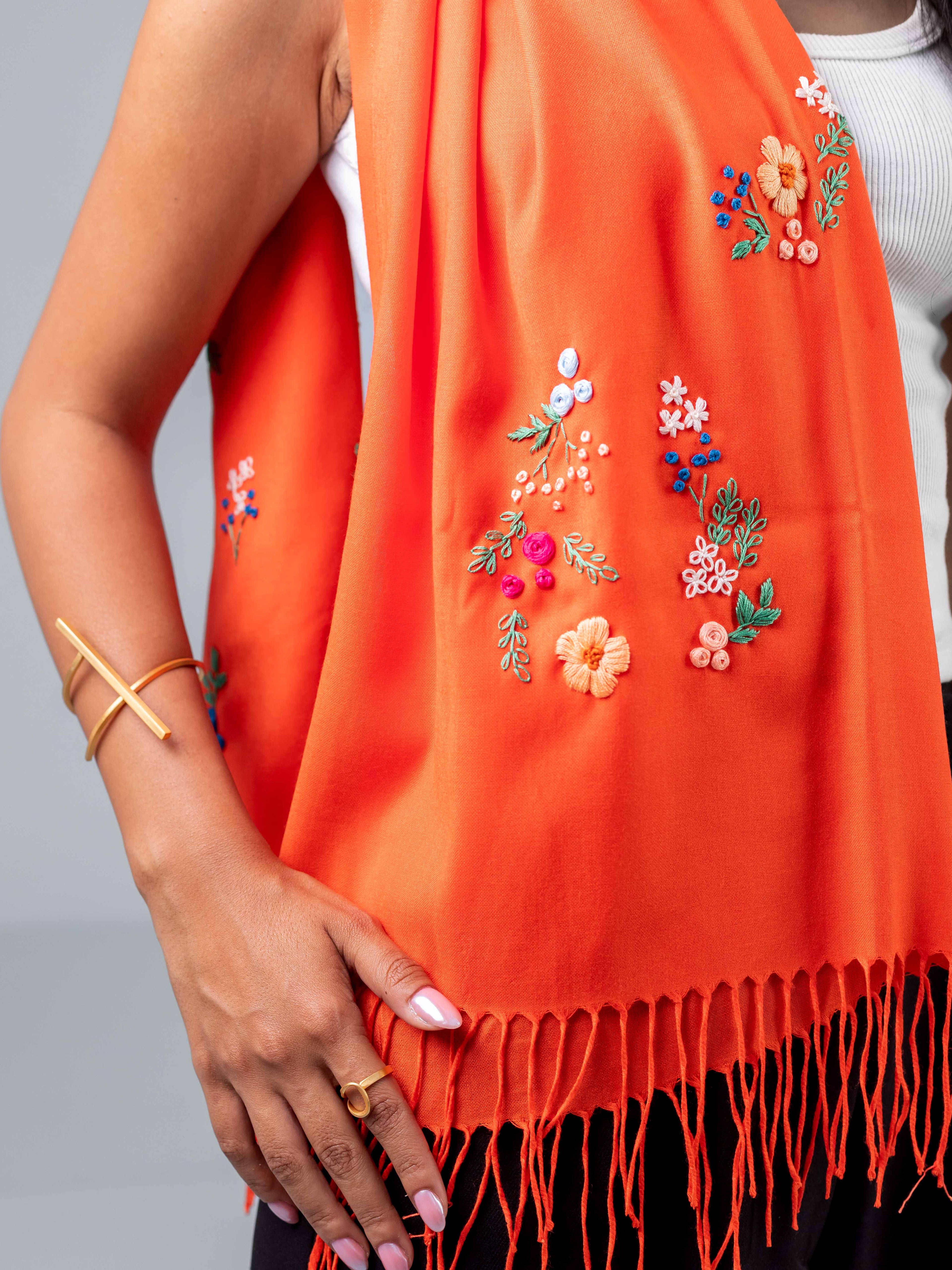 Gros plan sur la broderie de l'écharpe Nour brodée main Niléa et la manchette la ligne.