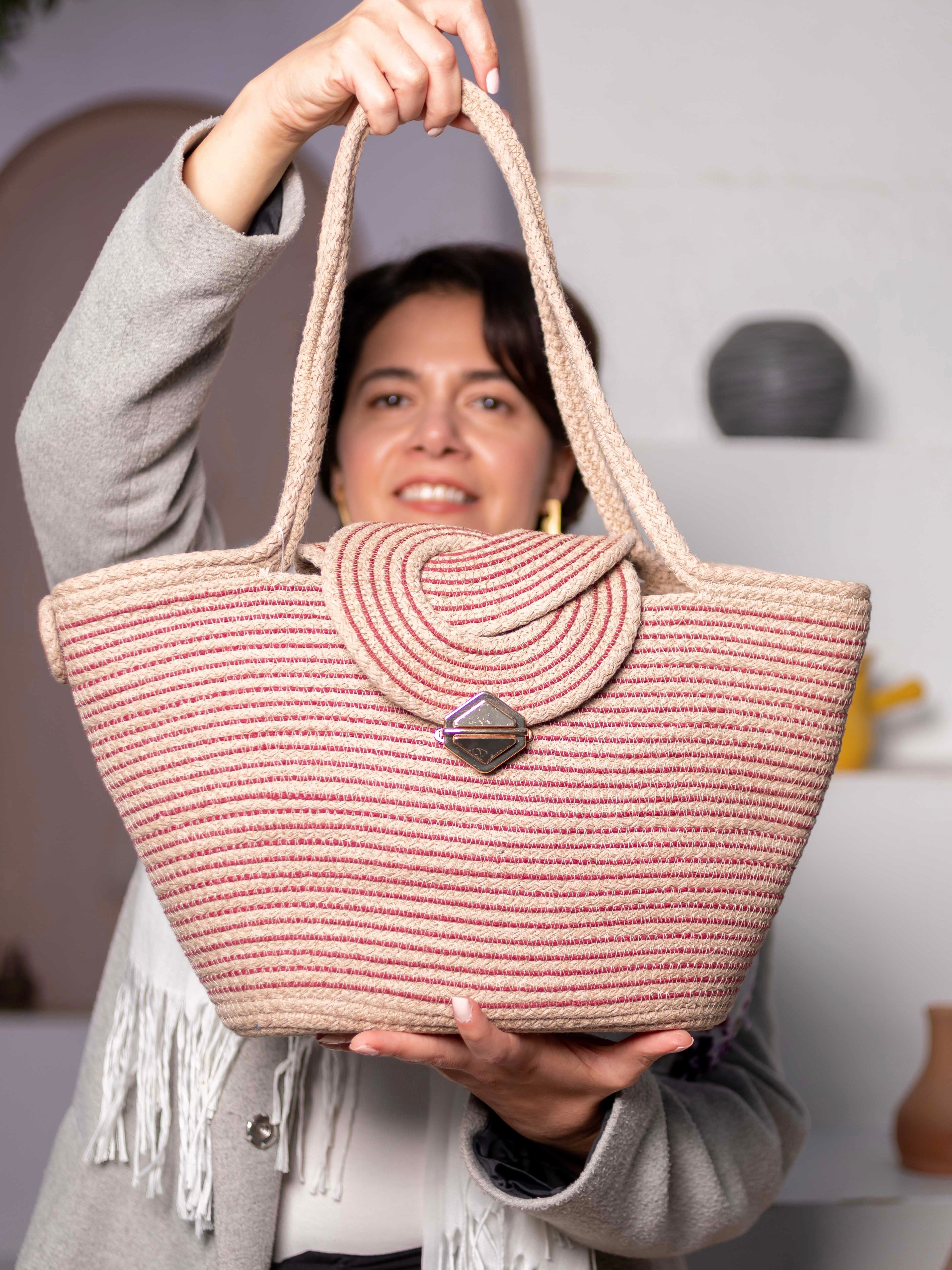 Cabas Nubia beige et rouge en corde de coton porté à la main.