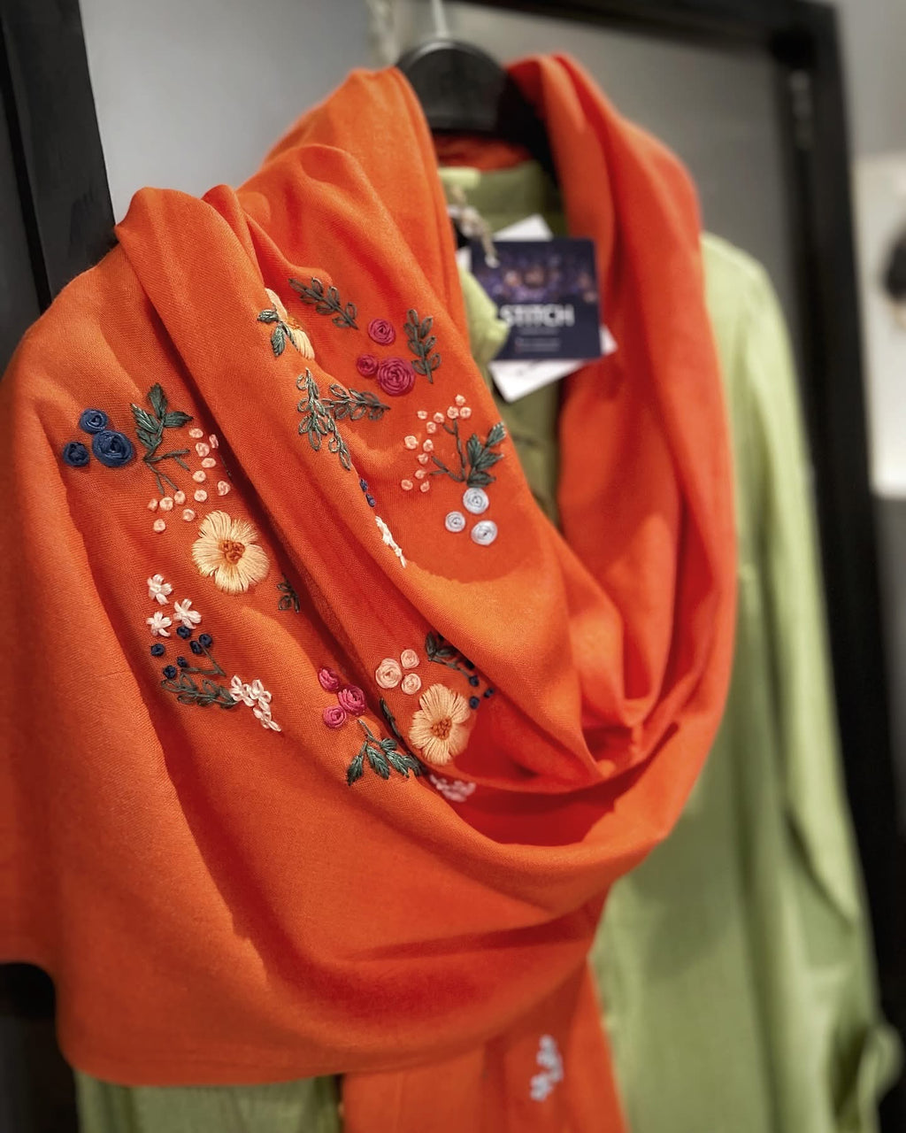 Écharpe orange Nour portée nouée autour du cou, broderies artisanales visibles