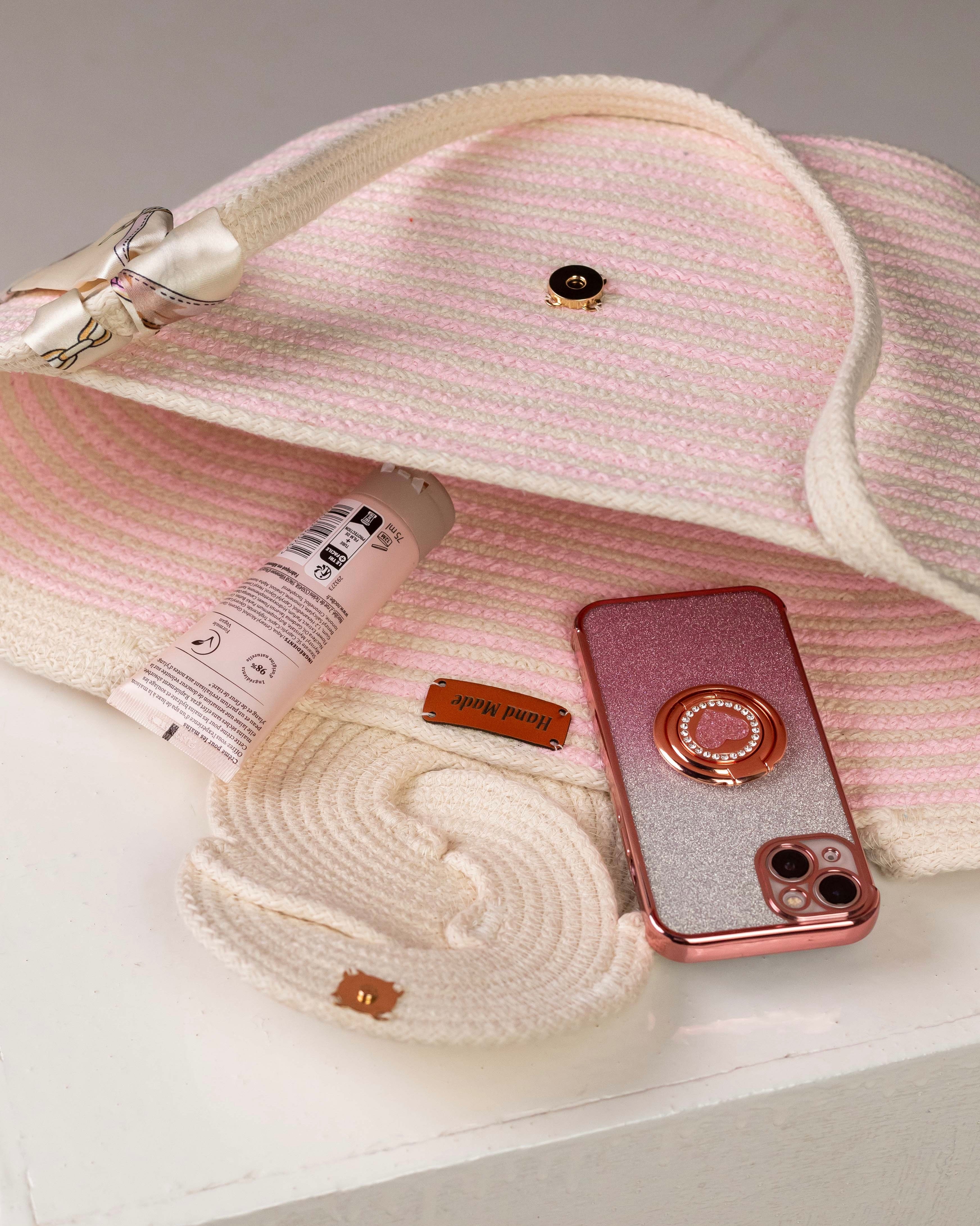 Vue plongeante sur l'intérieur ouvert du sac Héliopolis, montrant sa capacité avec un téléphone portable, une crème pour les mains et son bouton de fermeture aimanté sur le rabat en relief.