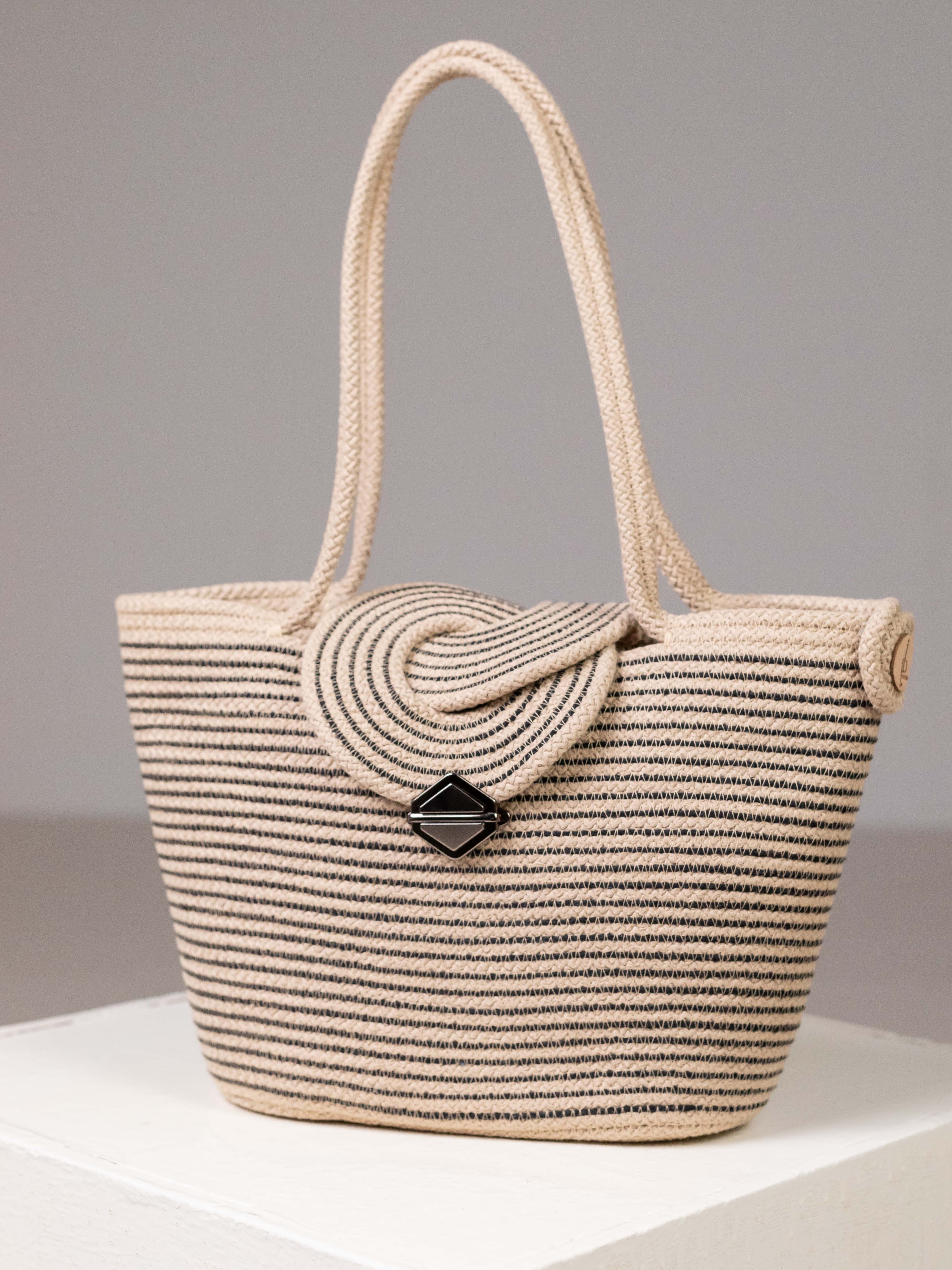 Sac cabas Sahara bicolore beige et noir en corde de coton tressée, posé en studio avec son rabat en relief et son fermoir design.